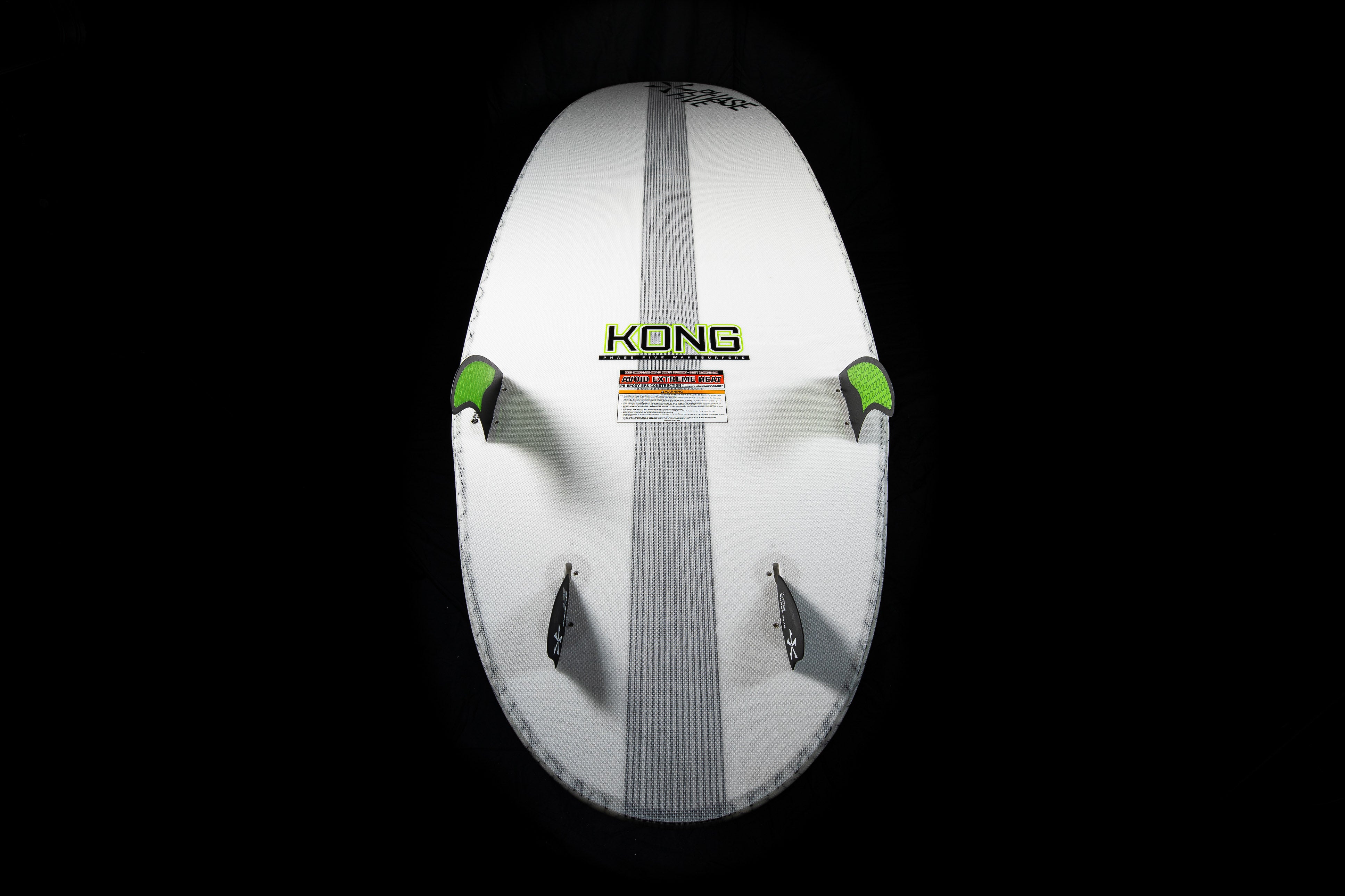 White 2025 Phase 5 Kong surfboard with black and green foot straps, centered logo, and warning label, against a black background.