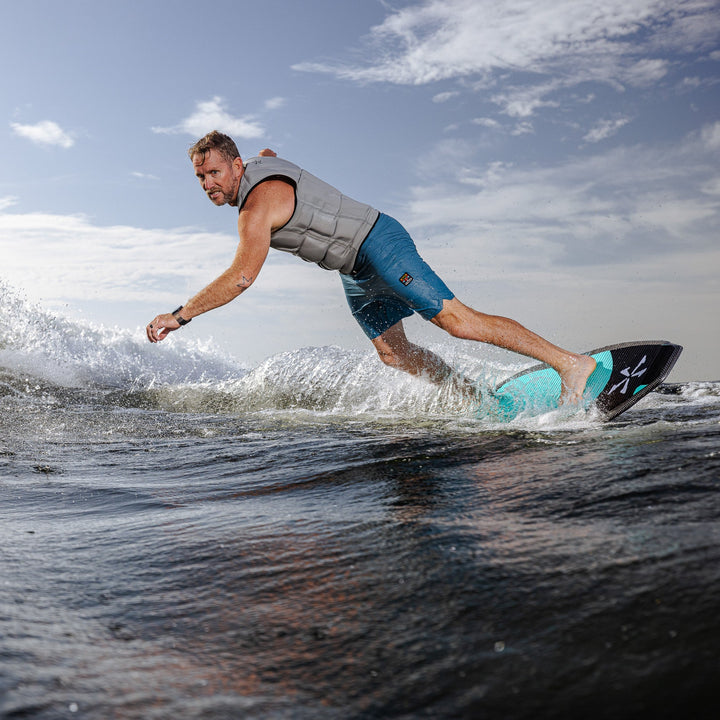 A man rides the 2026 Phase Five Hammerhead V3 surfboard on a wave, showcasing its sleek design and performance.