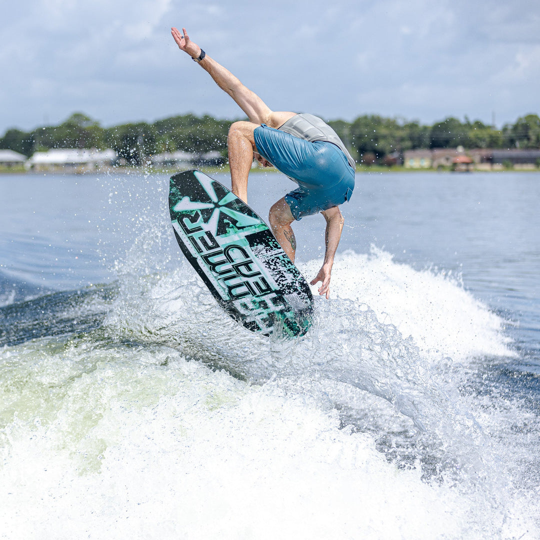Rider performing a trick on the 2026 Phase Five Hammerhead V3 wake surfboard, creating a spray of water behind.