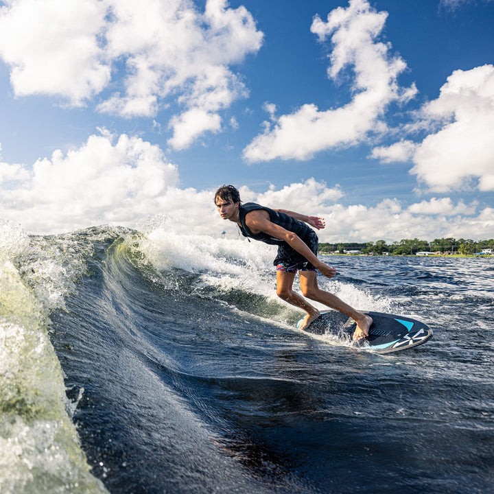 A surfer rides a wave on a 2026 Phase Five Hypsta V2 board, showcasing agility and skill on the water.