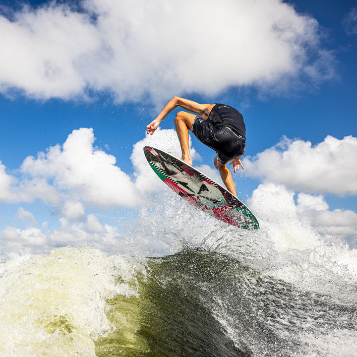 A person performing a jump on a wakeboard over a wave, showcasing the 2026 Phase Five Key CL in action.