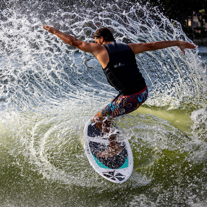 A surfer skillfully rides a wave on the 2026 Phase Five Key CL, showcasing dynamic movement and spray.