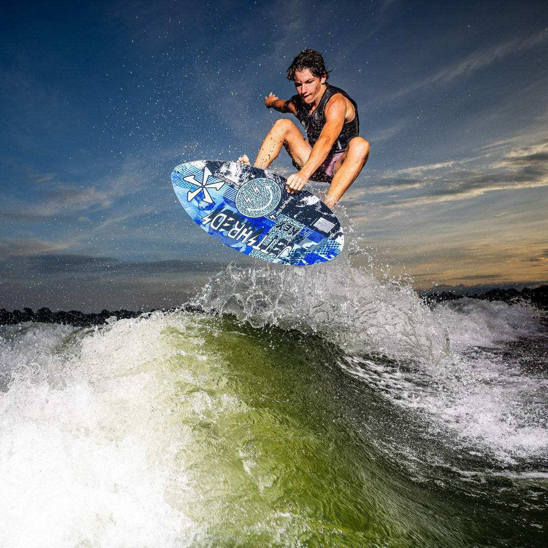 A rider performs a jump on the 2026 Phase Five Key Jett Shreds surfboard above a wave, showcasing dynamic action and skill.