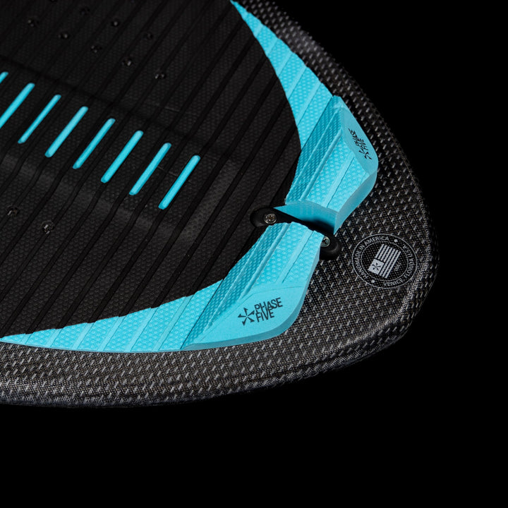 Close-up of the 2026 Phase Five Key Jett Shreds surfboard featuring a textured black surface with blue accents.