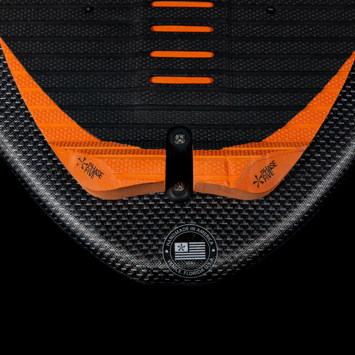 Close-up of the 2026 Phase Five Key Stewart Pro wakeboard, featuring a textured surface and vibrant orange accents.
