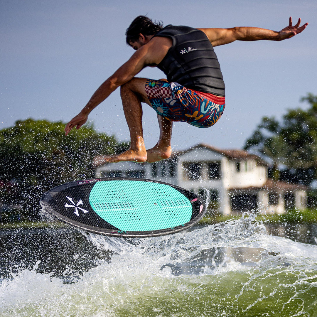 A person in a life vest jumps off a surfboard, creating a splash on the water, showcasing the 2026 Phase Five Key V2.