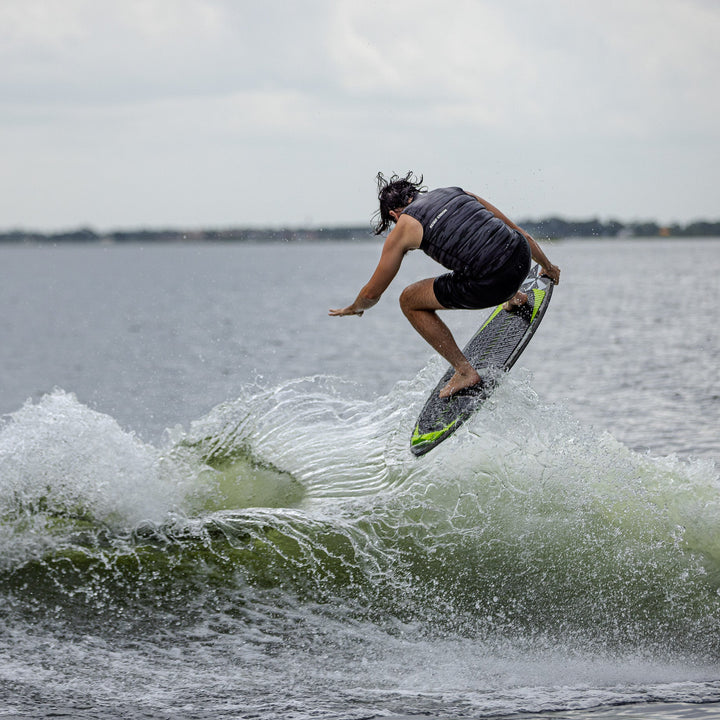 A rider performs a jump on the 2026 Phase Five Matrix surfboard, creating a splash in the water.