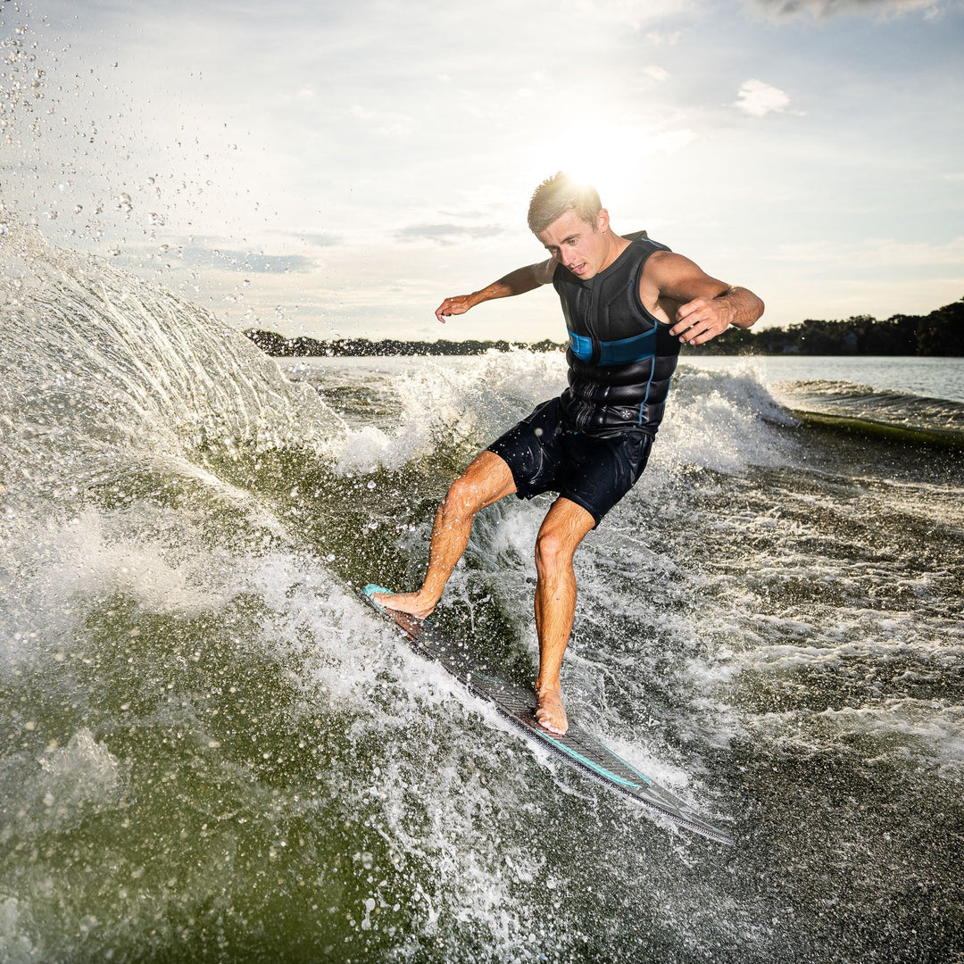 A person riding the 2026 Phase Five Matrix Pro wakesurf board, carving through waves on a sunny day.