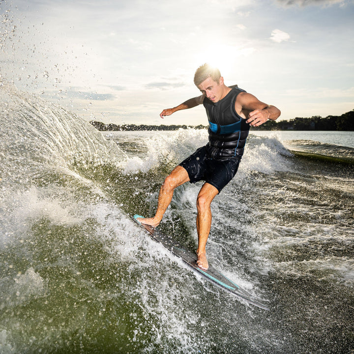 A person riding the 2026 Phase Five Matrix Pro wakesurf board, carving through waves on a sunny day.