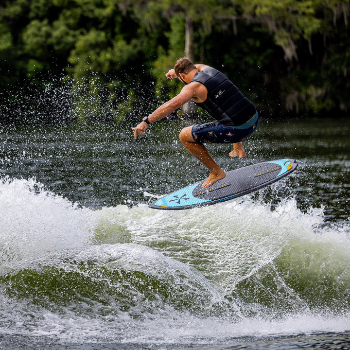 A person performing a jump on a 2026 Phase Five MVP V4 surfboard over a wave, showcasing water sports action.