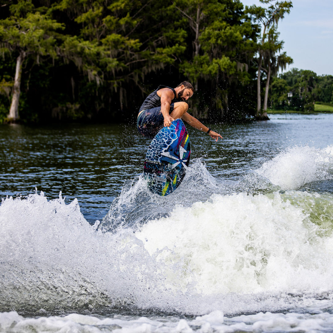 A rider performs a jump on the 2026 Phase Five MVP V4 wake surfboard, creating a splash in the water.