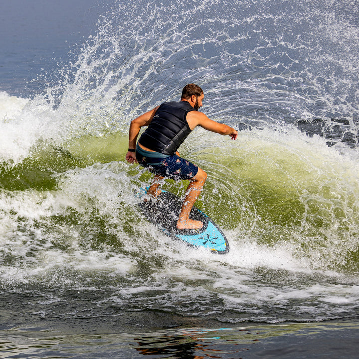 A person riding the 2026 Phase Five MVP V4 wakesurf board, creating a splash on the water.