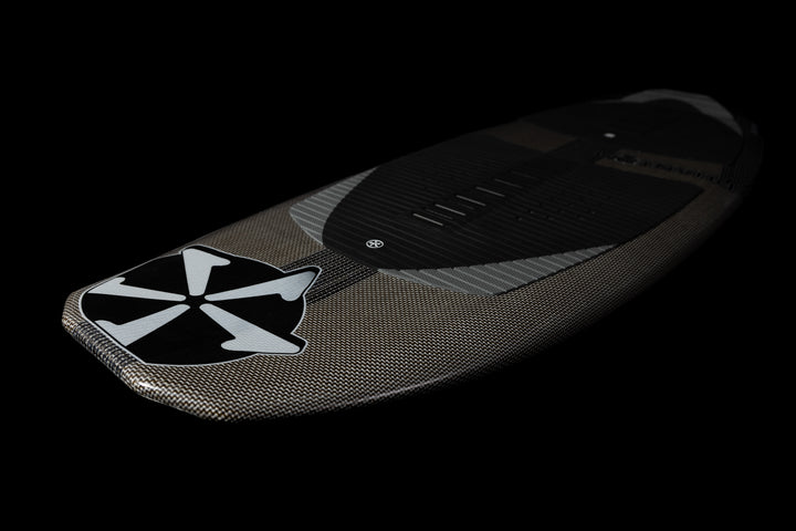 A sleek, black and gray Phantom Stealth surfboard with a stylized skull logo on the nose, designed for 2025 performance.