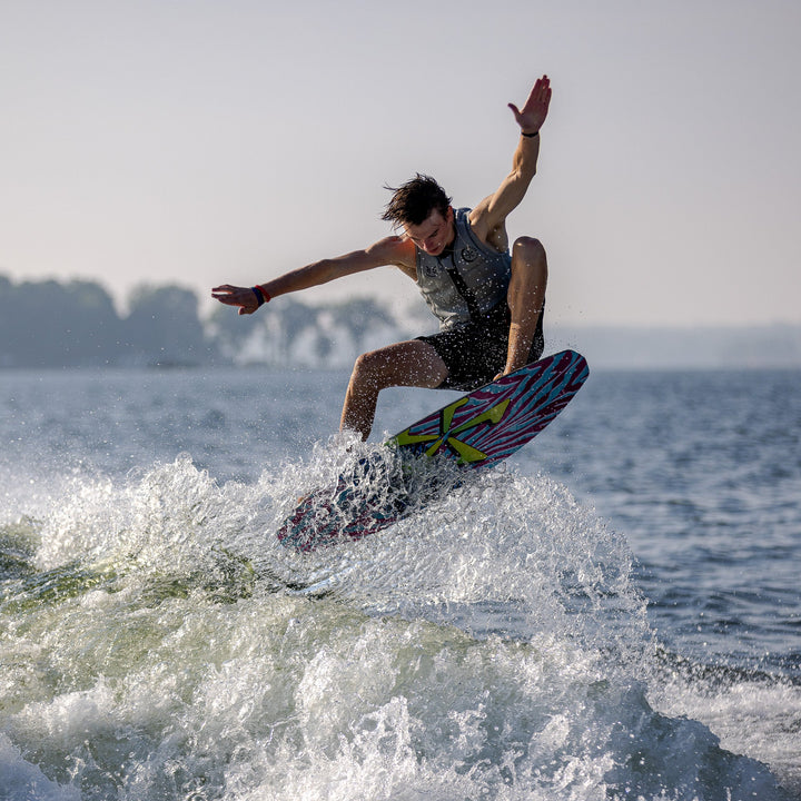 A wakeboarder performs a trick on the 2026 Phase Five Party Crasher, showcasing agility and style on water.