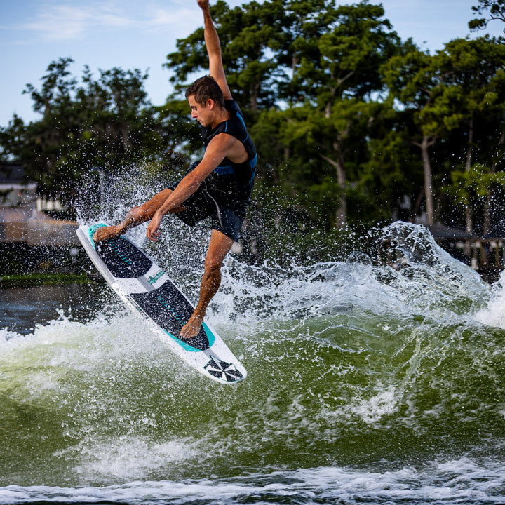 A rider performs an aerial maneuver on a 2026 Phase Five Phantom surfboard, showcasing agility and skill on water.