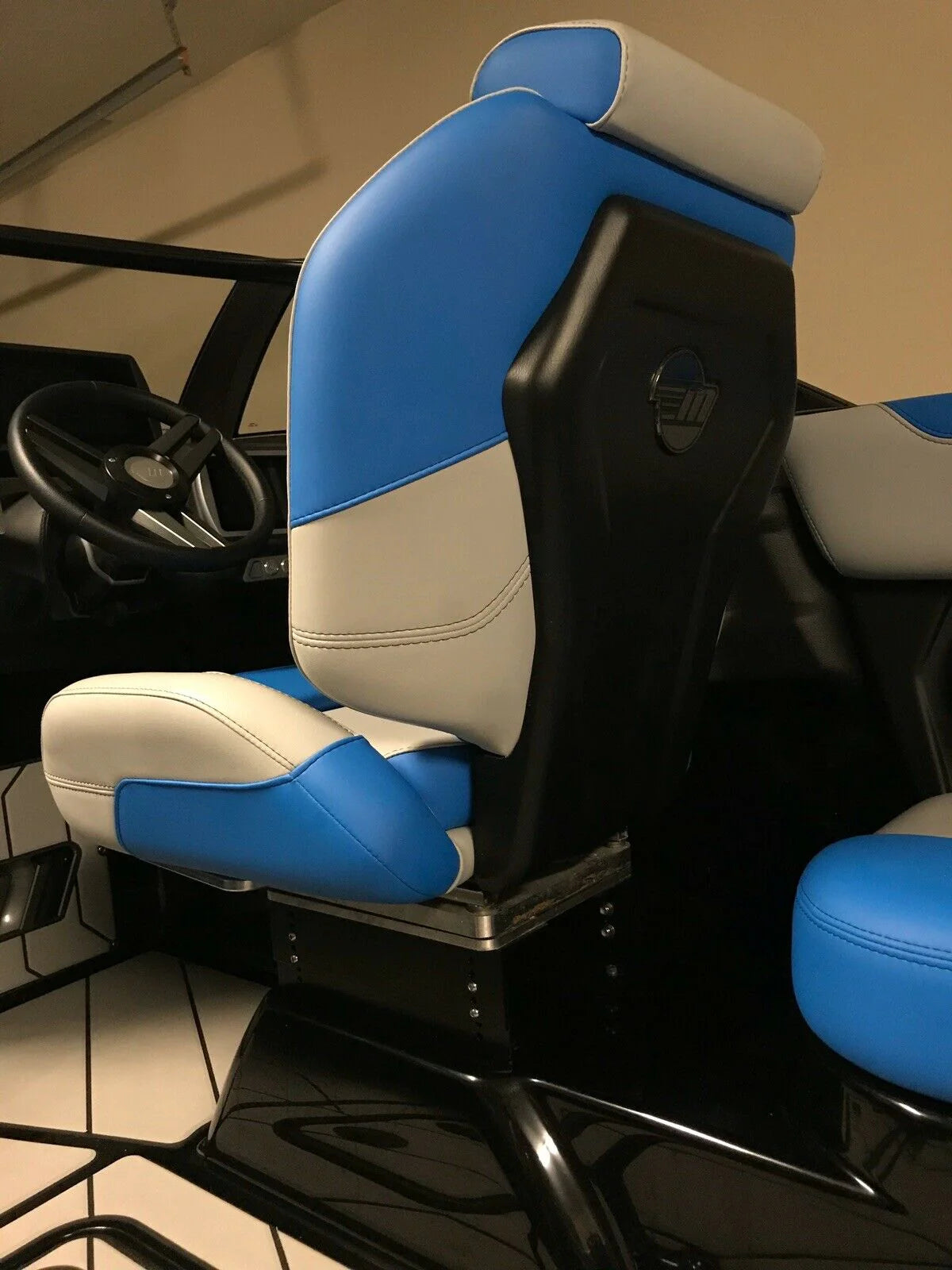 Seat riser for Malibu/Axis boat, with blue and white cushioned upholstery, elevates the seat for better visibility and comfort.