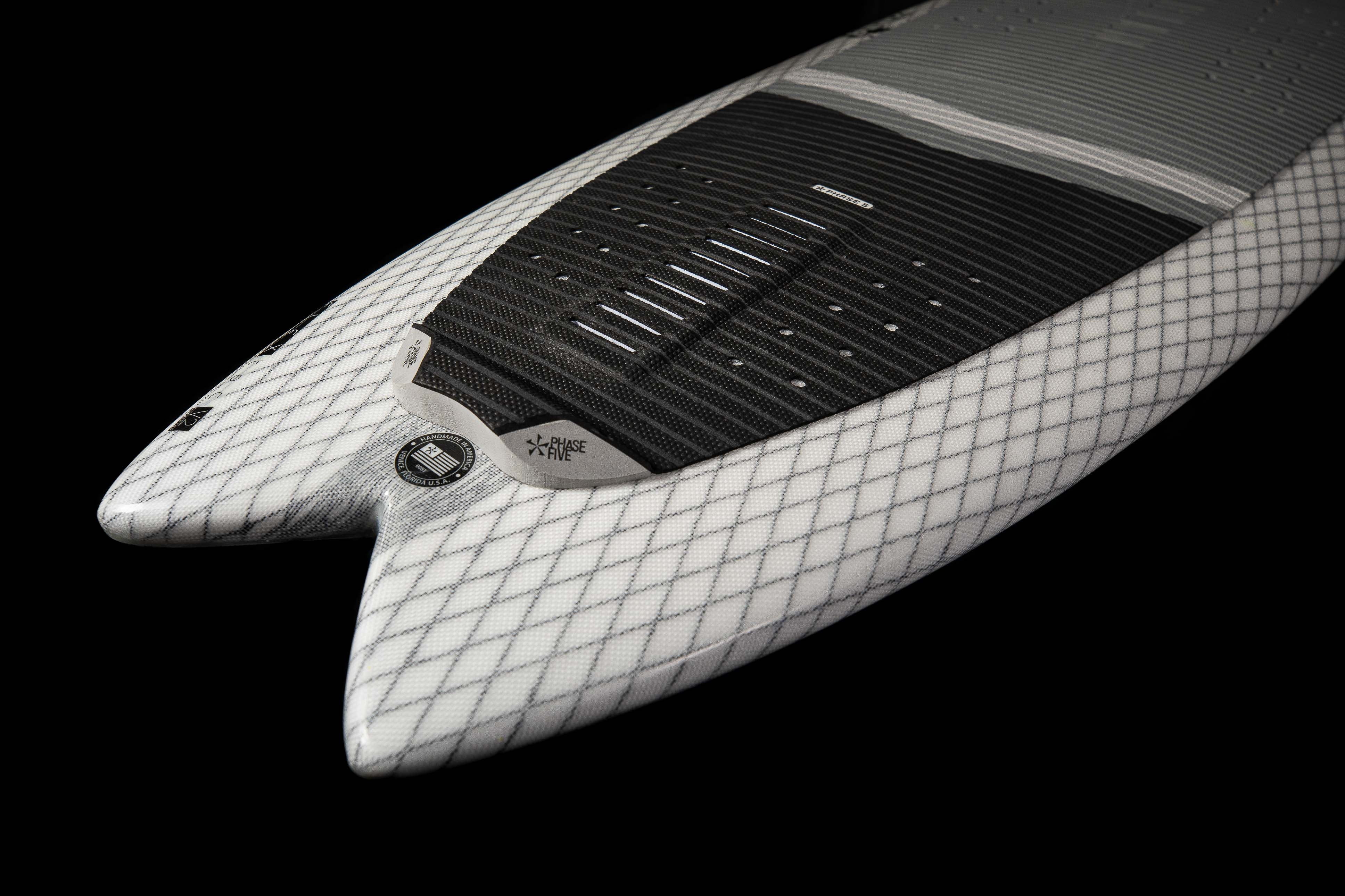 Close-up of the 2025 Phase 5 Zilla surfboard featuring a white diamond-patterned deck, black traction pad, and sleek design.