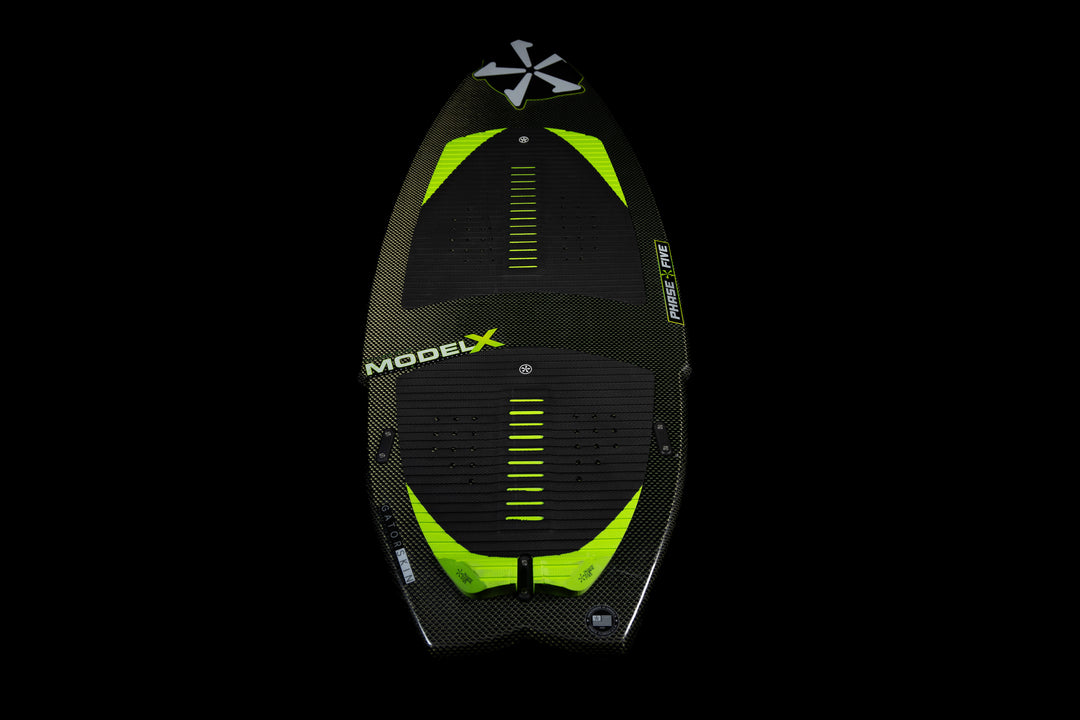 2025 Phase 5 Model X Skim Board featuring a sleek design with a black and neon green color scheme and textured foot pads.