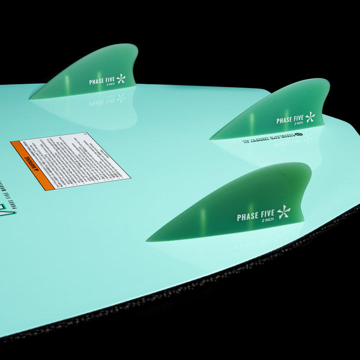 Close-up of the 2026 Phase Five Trident V3 wake surfboard fins, showcasing their green color and sleek design.