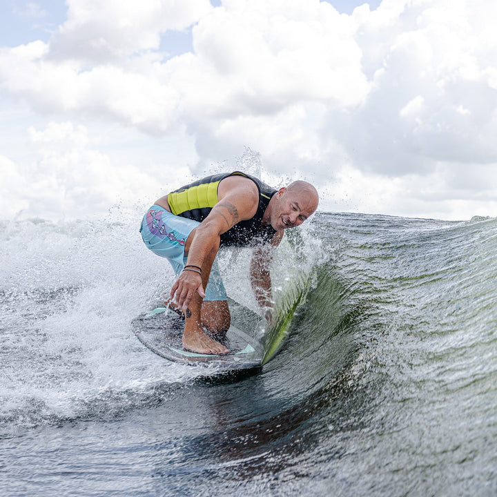 A person riding a surfboard on a wave, showcasing the 2026 Phase Five Trident V3 in action.