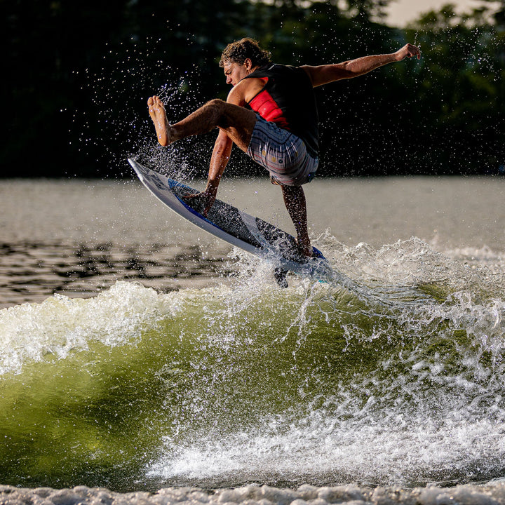 A person performs a jump on a 2026 Phase Five Viper surfboard, creating a splash on a wave.