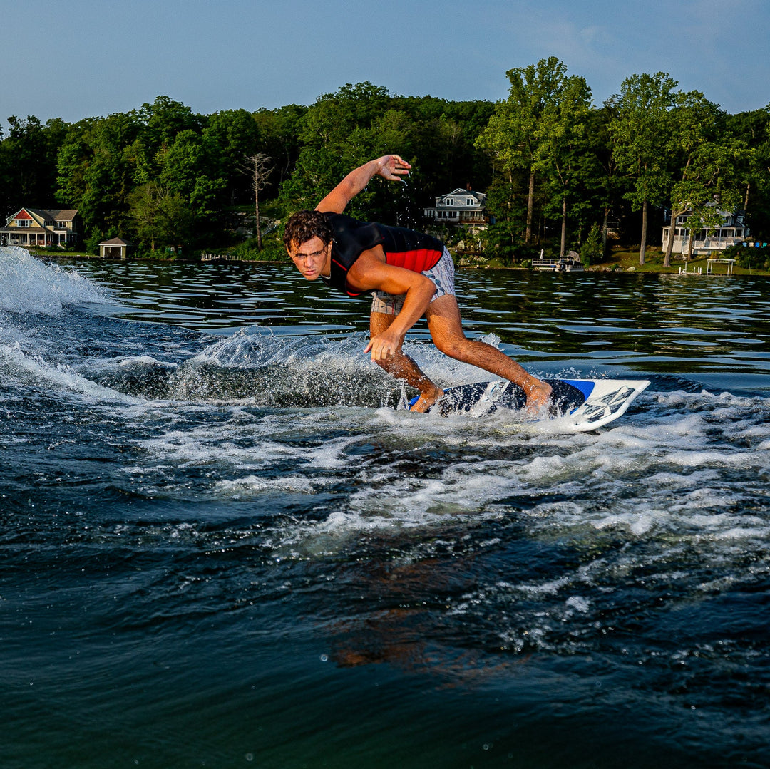 A rider skillfully maneuvers the 2026 Phase Five Viper surfboard on a lake, showcasing water sports excitement.