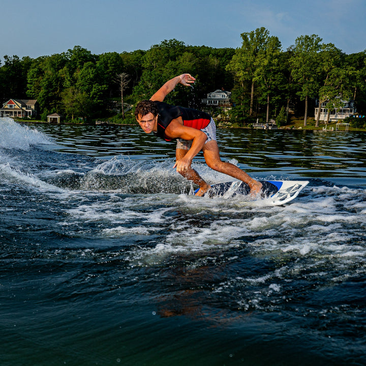 A rider skillfully maneuvers the 2026 Phase Five Viper surfboard on a lake, showcasing water sports excitement.