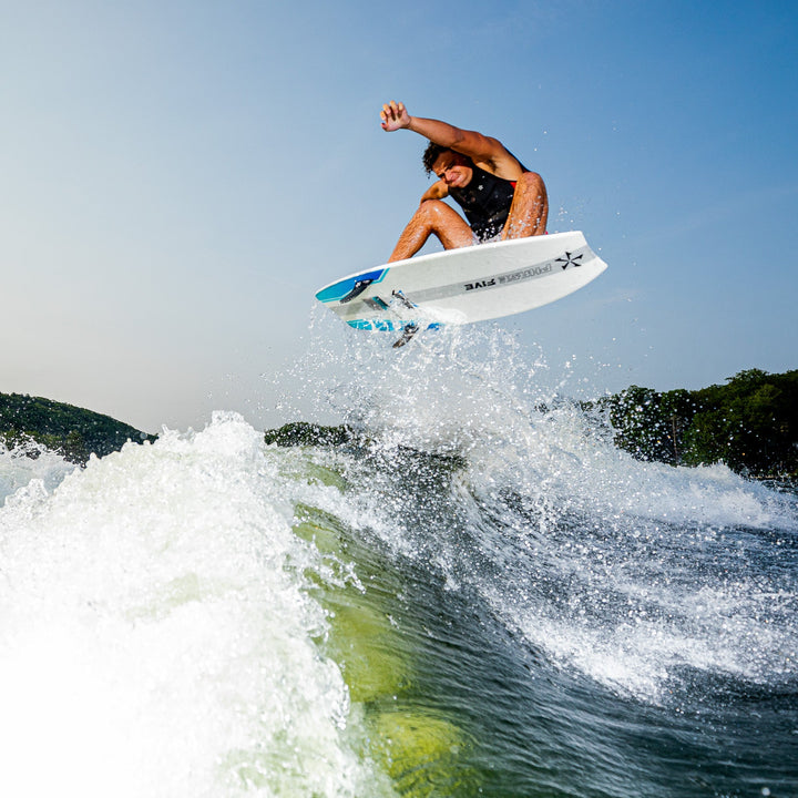 A person performs a jump on a 2026 Phase Five Viper surfboard over a wave, showcasing dynamic water sports action.