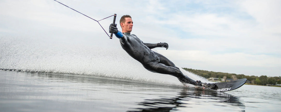 A person waterskiing in a Syndicate DRY-FLEX wetsuit, showcasing flexibility and performance on the water.