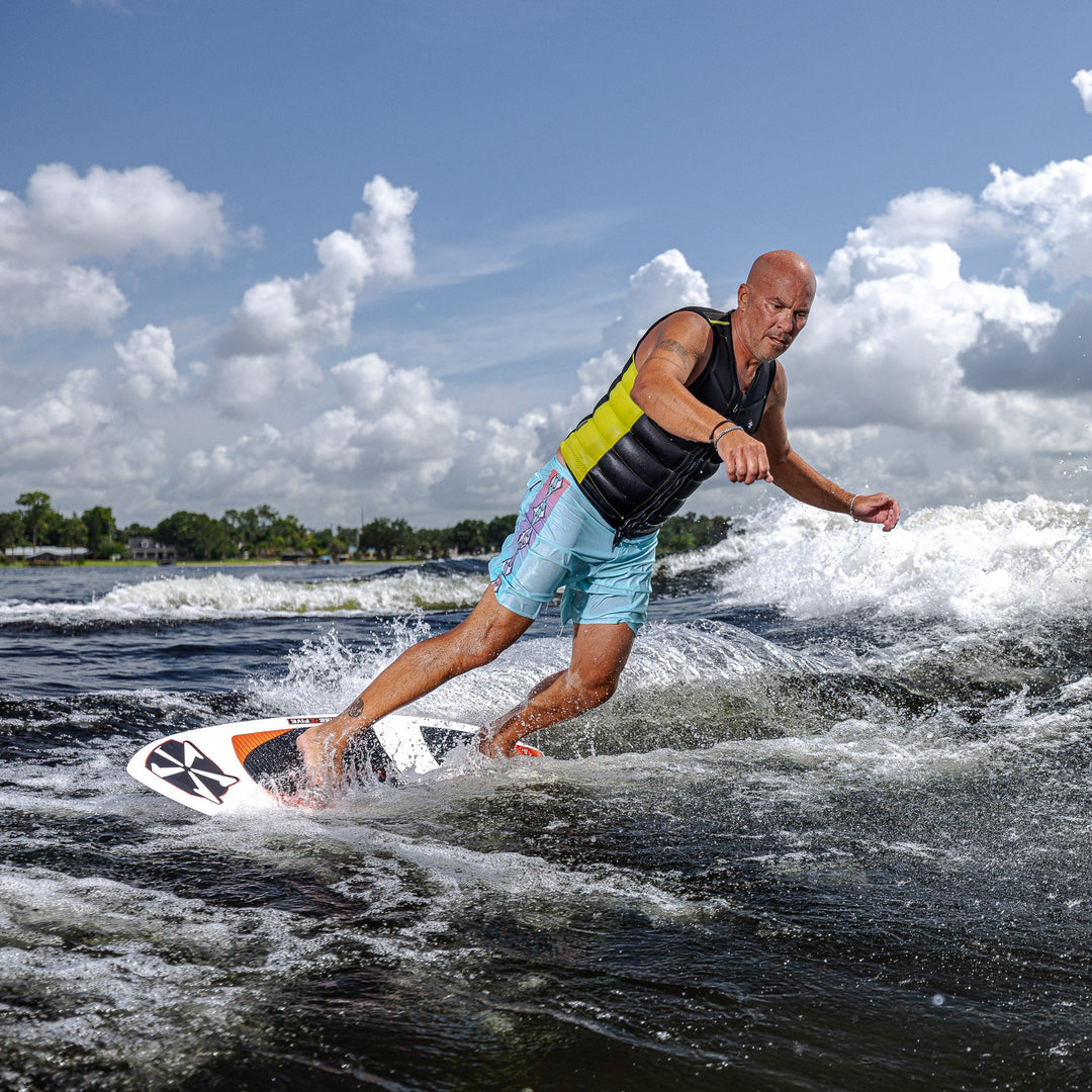 A person surfing on a 2026 Phase Five XB board, showcasing dynamic movement on a wave under a bright sky.