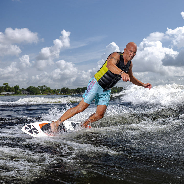 A person surfing on a 2026 Phase Five XB board, showcasing dynamic movement on a wave under a bright sky.