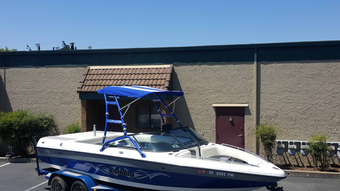 Over the Tower Bimini installed on a Skylon Swoop Tower boat, featuring a blue canvas shade and metal frame.