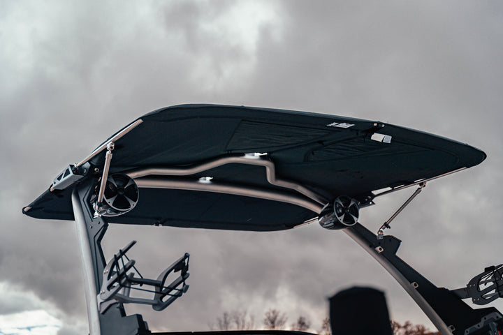 Malibu VTX Bimini with ski tower and canopy, mounted on a boat against a cloudy sky background.