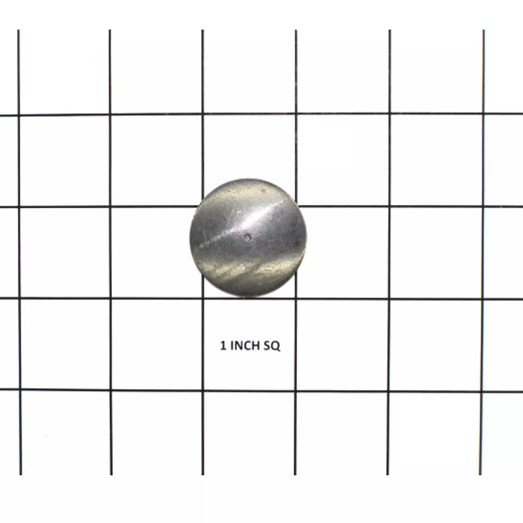 Weld-in manifold plug, 1-inch diameter, metal, spherical shape, placed on a grid for size reference.