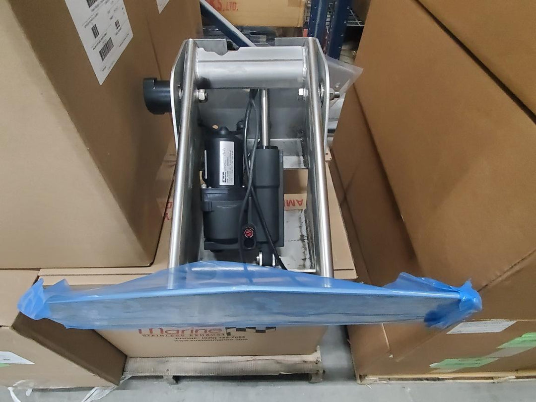 Axis Power Wedge III assembly with motor, mounted on a metal frame, surrounded by cardboard boxes in a warehouse.