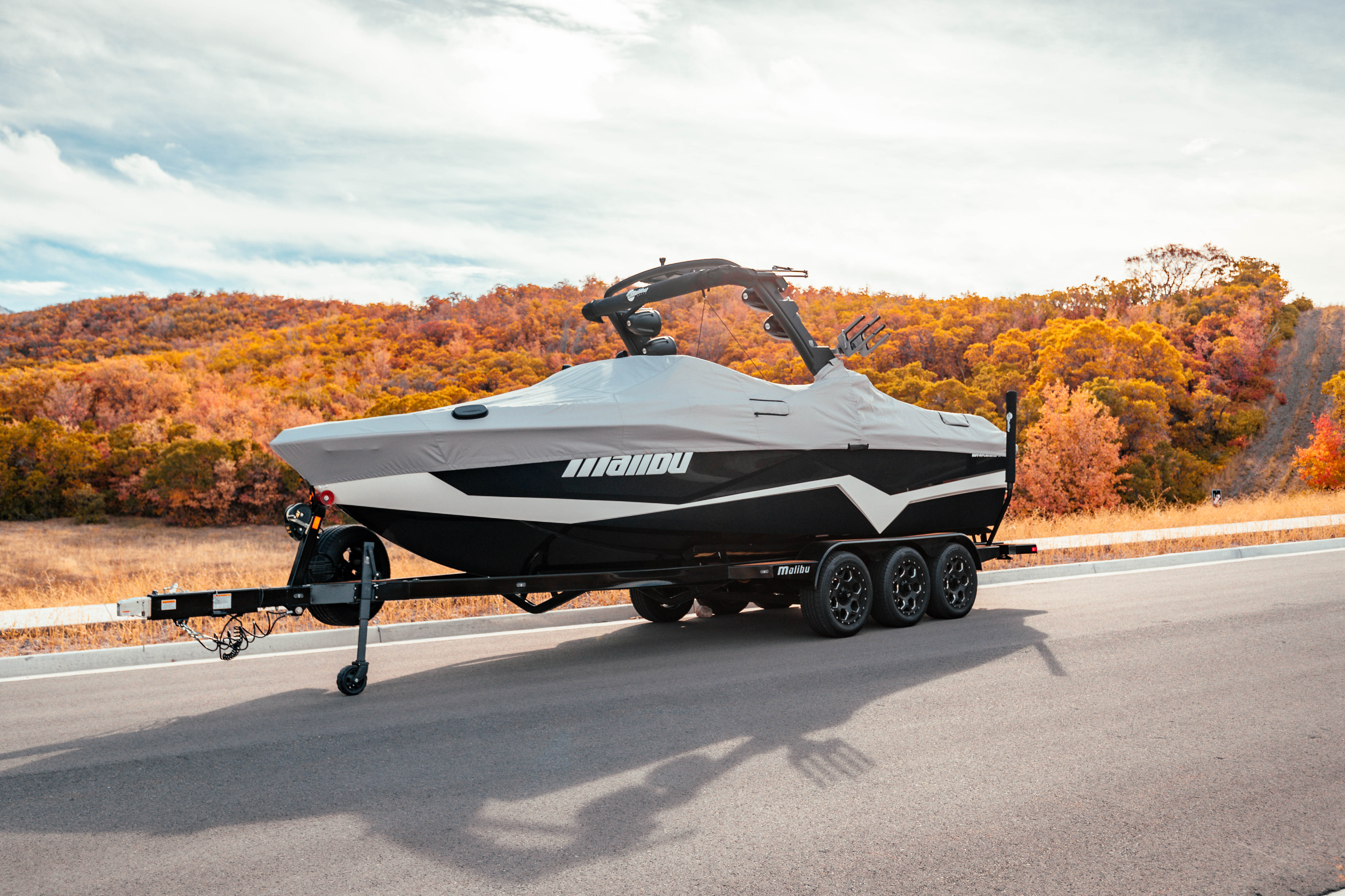 2018 25 LSV boat cover on a trailer, featuring a G3.5 tower and swim platform, set against a scenic autumn backdrop.