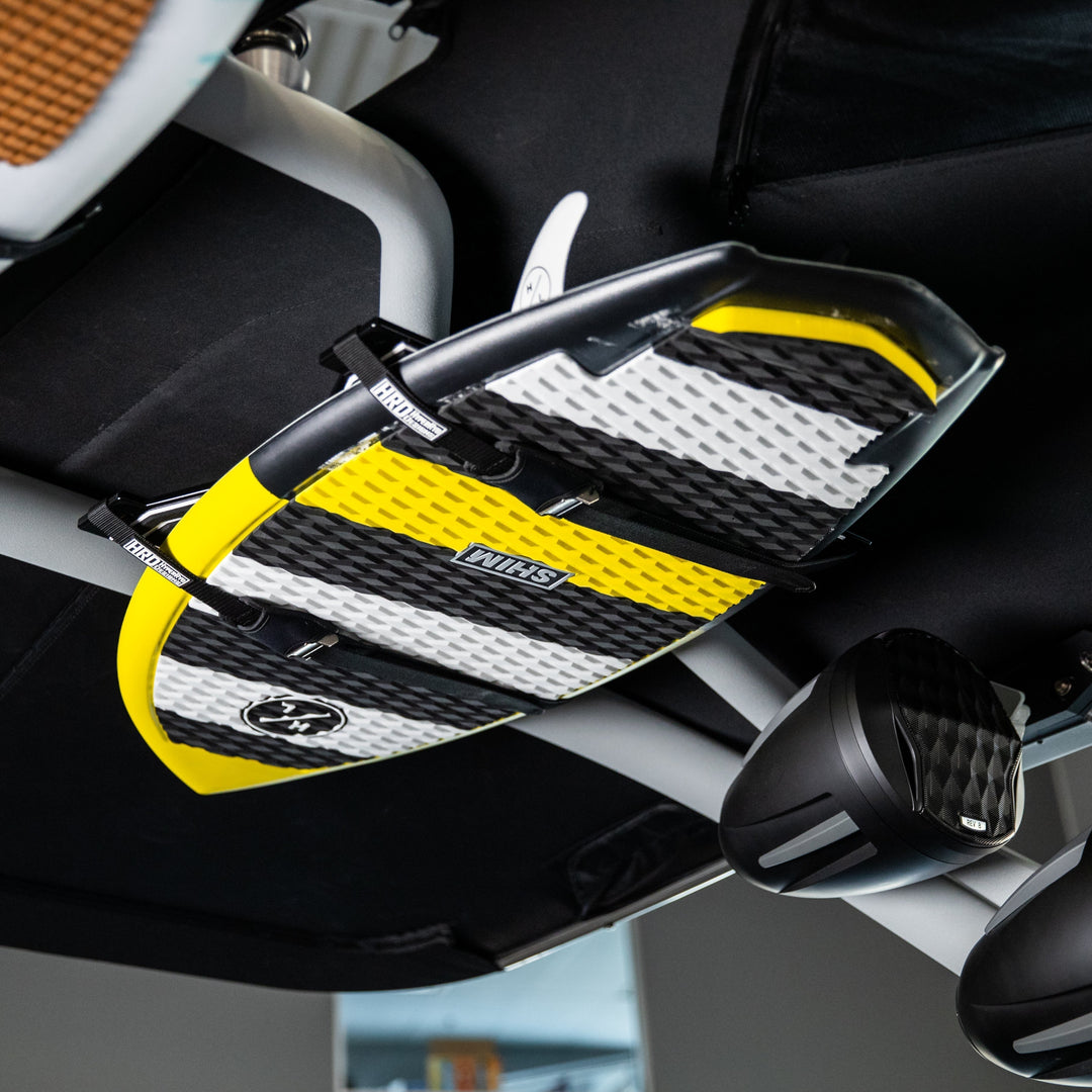 XR1 Surf Rack with GX Towers mounted under a vehicle ceiling, holding a yellow, black, and white surfboard.