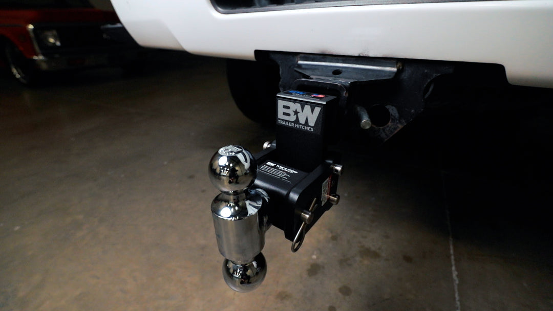 Black B&amp;W Tow &amp; Stow adjustable ball mount with chrome hitch ball attached to a vehicle&