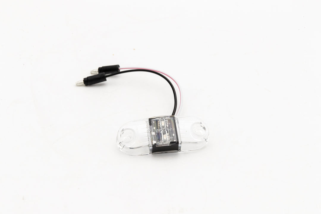 Clear lens LED clearance light with red LED and wiring for vehicle or equipment use.