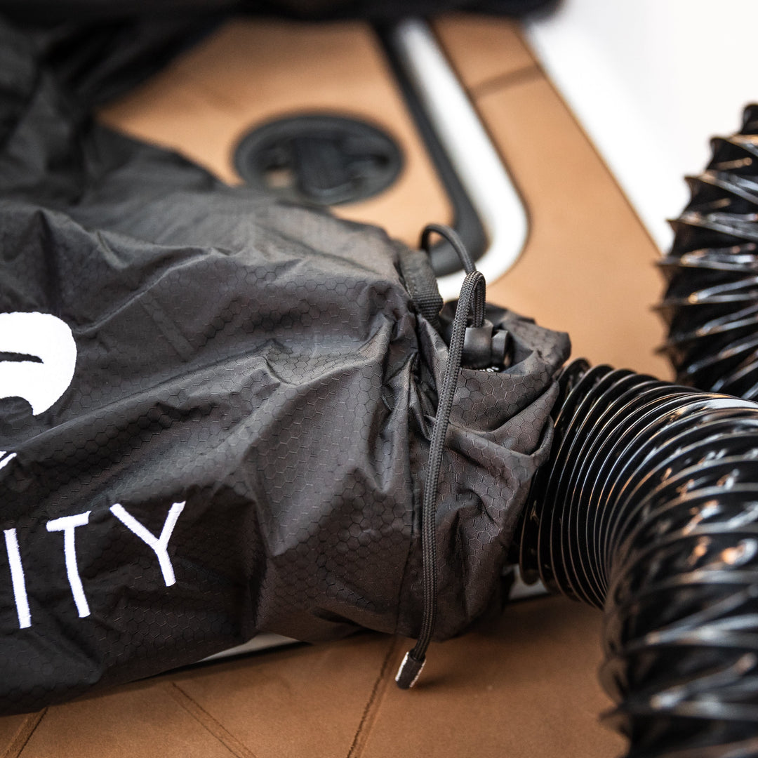 Heated boat blanket by Surfinity with adjustable drawstrings, placed on a boat deck with a portable speaker nearby.